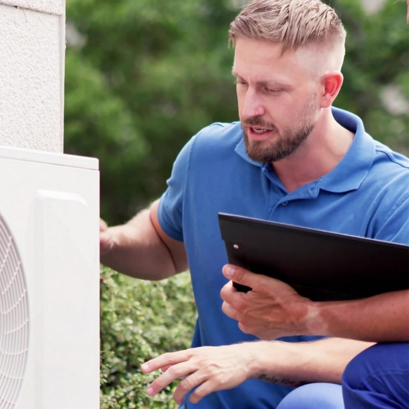 HVAC technician explaining heating and cooling service options to a homeowner in Williamsport, PA.