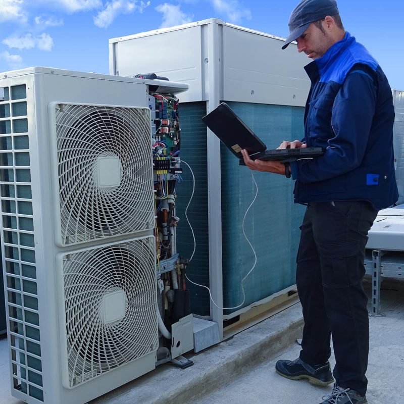 HVAC technician inspecting a commercial rooftop HVAC system in Williamsport, PA.
